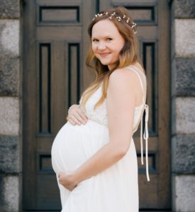 Pregnant Mom in white dress smiling